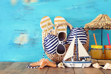 Naklejka premium vacation and summer concept with sea life style objects and fresh fruit drink over wooden table