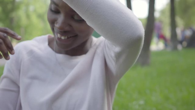 Positive African American woman playing with her little son using plastic toy in the park. The young mother spending time with her child outdoors. Loving family on the picnic. Summertime leisure
