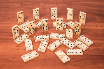 The wooden domino board game lies on a wooden table, soon the whole family will play this interesting game for everyone