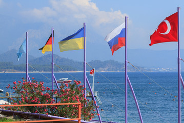 Fototapeta na wymiar Flags of Turkey, Russia, Ukraine, Germany and Kazakhstan on the beach in Kemer