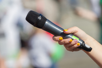 Female hand holds microphone
