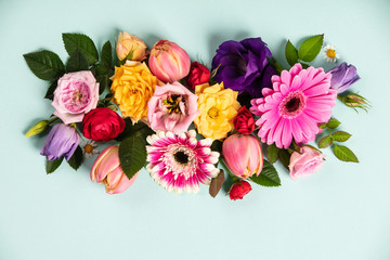 Creative layout made with beautiful flowers on blue background. Flat lay. Spring minimal concept