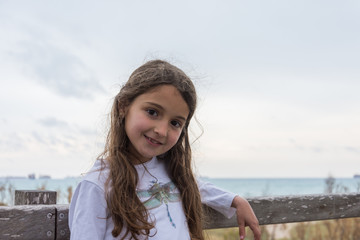 Little girl smiling with the sea in the background