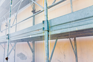 Metal scaffolding with plastic grid for the restoration of a building facade in a italian construction site