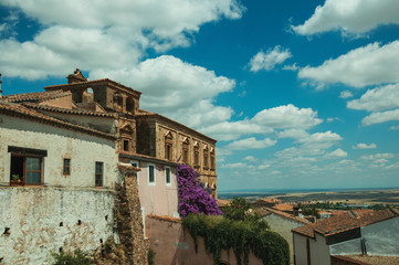 Old buildings and flowering trees with a countryside landscape at Caceres