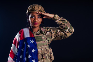 Young latin indian woman soldier with gun studio black background