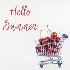 Ripe cherries in a shopping cart isolated