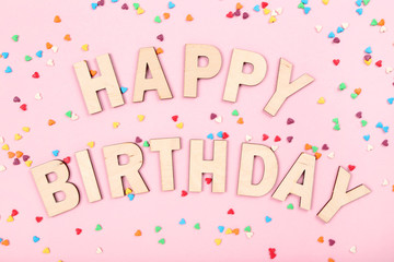Text Happy Birthday with small hearts on pink background