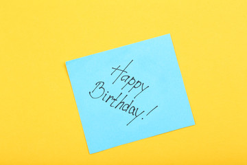 Paper with text Happy Birthday on yellow background