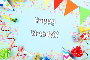 Text Happy Birthday with party decorations on blue background