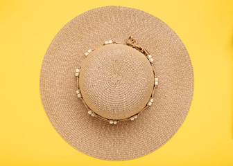 Brown beach hat on yellow background