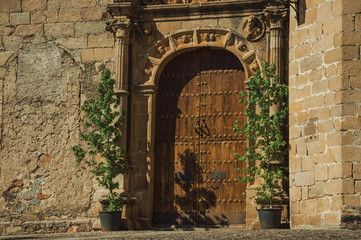 Gothic church facade with wooden door at Caceres