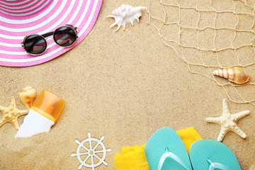 Beach clothing with seashells and fishing net on sand