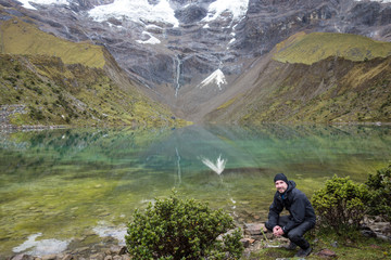 Backpacker in front of the Humantay Lake on the Salkantay Trail, the trek to Machu Picchu, Peru