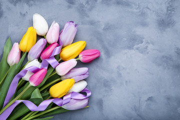 Bouquet of tulip flowers with ribbon on grey background