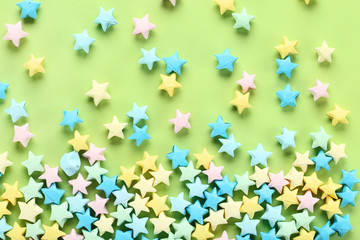 Colorful paper stars on green background