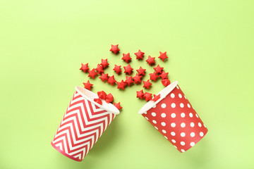 Fototapeta na wymiar Red paper stars with cups on green background