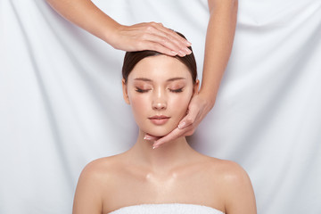 Naklejka premium young and beautiful female receiving facial treatment in spa