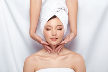 pretty woman in towel gets massage for her neck and face, fresh face receiving spa treatment, massaging and relaxation