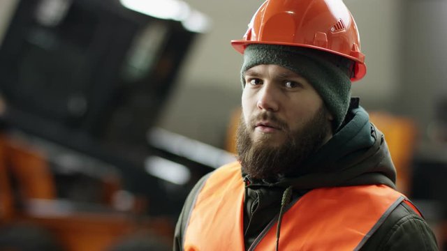 Cheerful young car mechanic in a car service. Accomplishes maintenance and organization mission by completing related results as needed. Verifies vehicle serviceability by conducting test drives