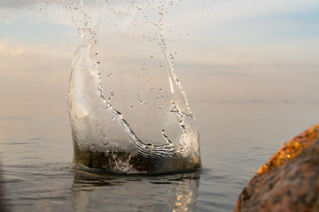big beautiful splash of water in the sea at sunset. natural desktop background