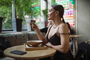 Sexy woman in bra eating food in asian cafe