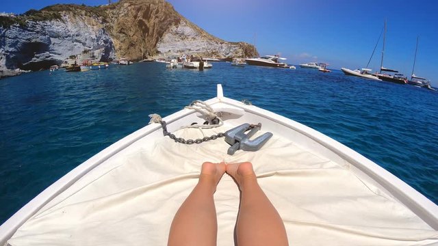 Woman legs and feet relaxing on a Boat Tanning while Sailing around Ponza island in italy