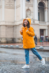 Fototapeta premium young pretty smiling woman portrait in raincoat with hood