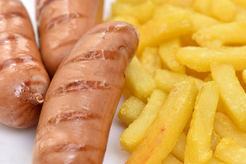 Street food. A dish of sausages and fried potatoes.