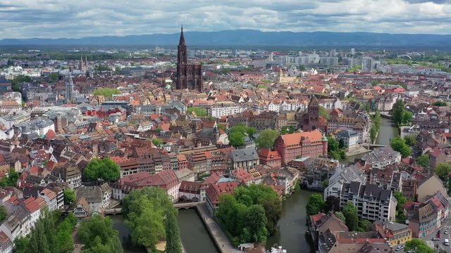 Aerial view of cityscape of Strasbourg, historic center of city, gothic Cathedral Notre-Dame de Strasbourg, dramatic clouds in sky - landscape panorama of France from above, Europe