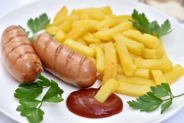 Street food. A dish of sausages and fried potatoes.