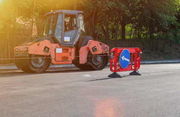 The machine lays asphalt, road repair, asphalt laying, road works, road roller, road repair sign