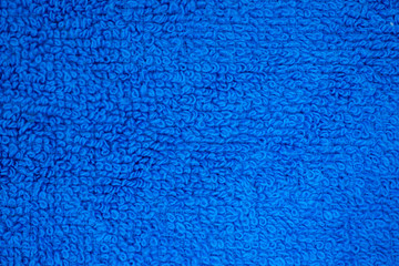 A mixture of multi-colored towels with a characteristic pattern. there is a round frame-lamp.