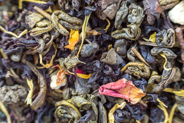 Close-up of dry tea herbal petals abstract dark colorful background. Healthy lifestyle, natural antioxidant drink, aromatherapy concept.