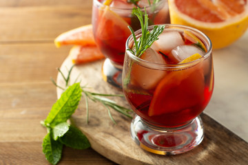 Grapefruit and rosemary gin cocktail, refreshing summer, cold pink drink. Wooden table.