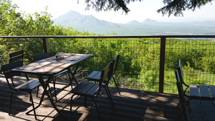 Table and chairs of one of the street restaurants with a beautiful view of the fields and mountains. Romantic meeting and outdoor recreation