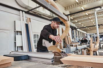 Fototapeta premium A lasting value. Focused carpenter at work with wooden plank
