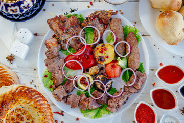Top view of barbecue meat plate, grilled meat over the white table.