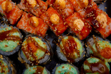 set of different sushi rolls on black background close-up