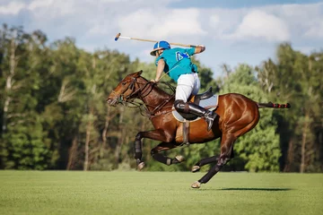 Tuinposter Horse polo player hit the ball with a mallet in action. Profile side view © Svetlana