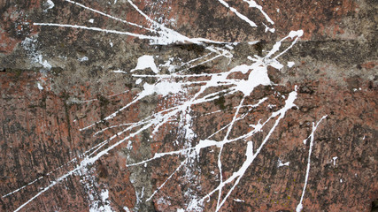 splashes of white paint on red brick