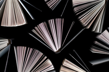 top view of half-opened books on black background