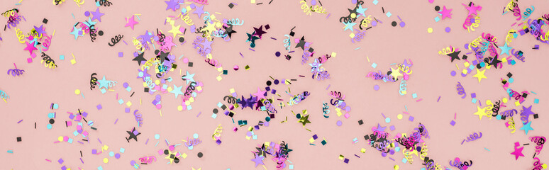 Panoramic shot of colorful confetti on pink party background