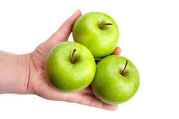 three ripe green apples in hand on white background