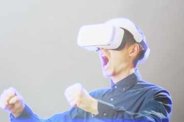 Man with virtual reality headset is playing game. Image with hologram effect.