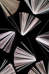 Naklejka premium top view of half-opened books on black background