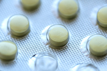 metal plate with yellow tablets, one pill used, medicine concept