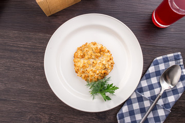 Fried pork chops in breadcrumbs on white plate on wooden table