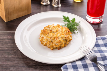 Fried pork chops in breadcrumbs on white plate on wooden table