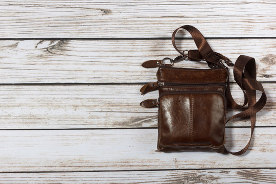 mens leather shoulder bag on wooden background